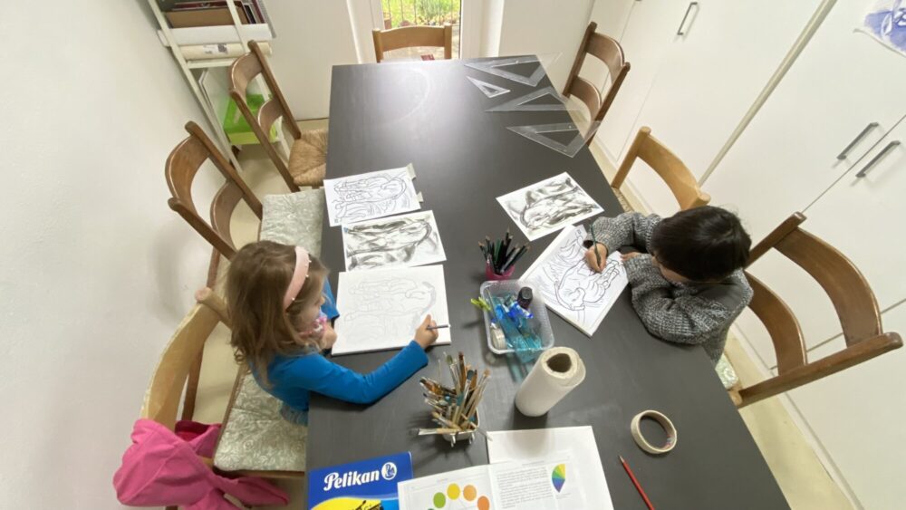 Due bambini piccoli disegnano un cavallo