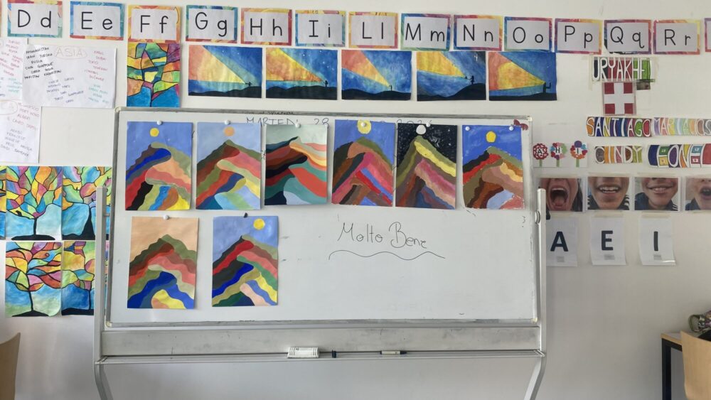 Creazioni degli allievi appese sulla lavagna durante un corso di pittura.